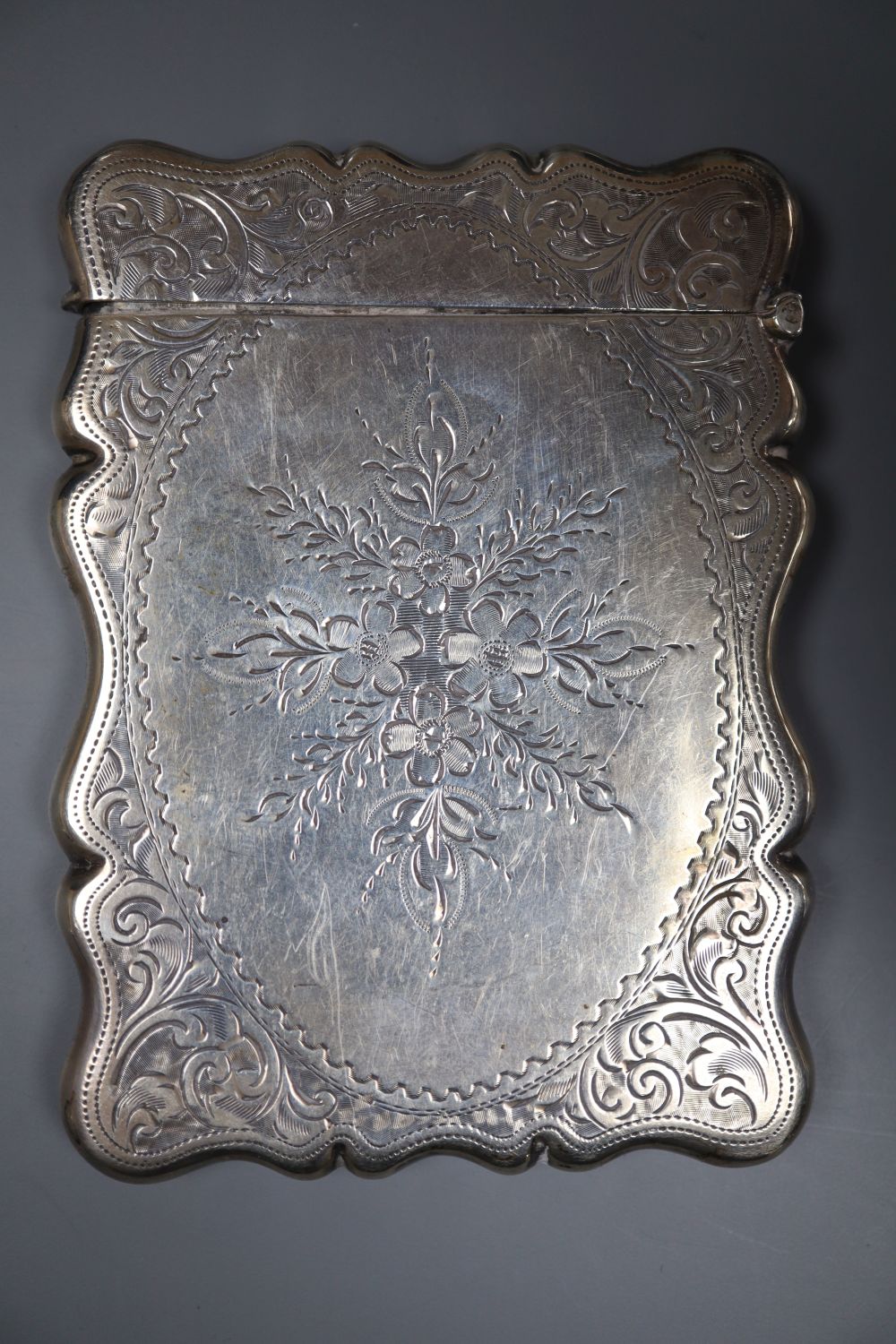 An Edwardian engraved silver card case, Birmingham, 1909, 94mm.